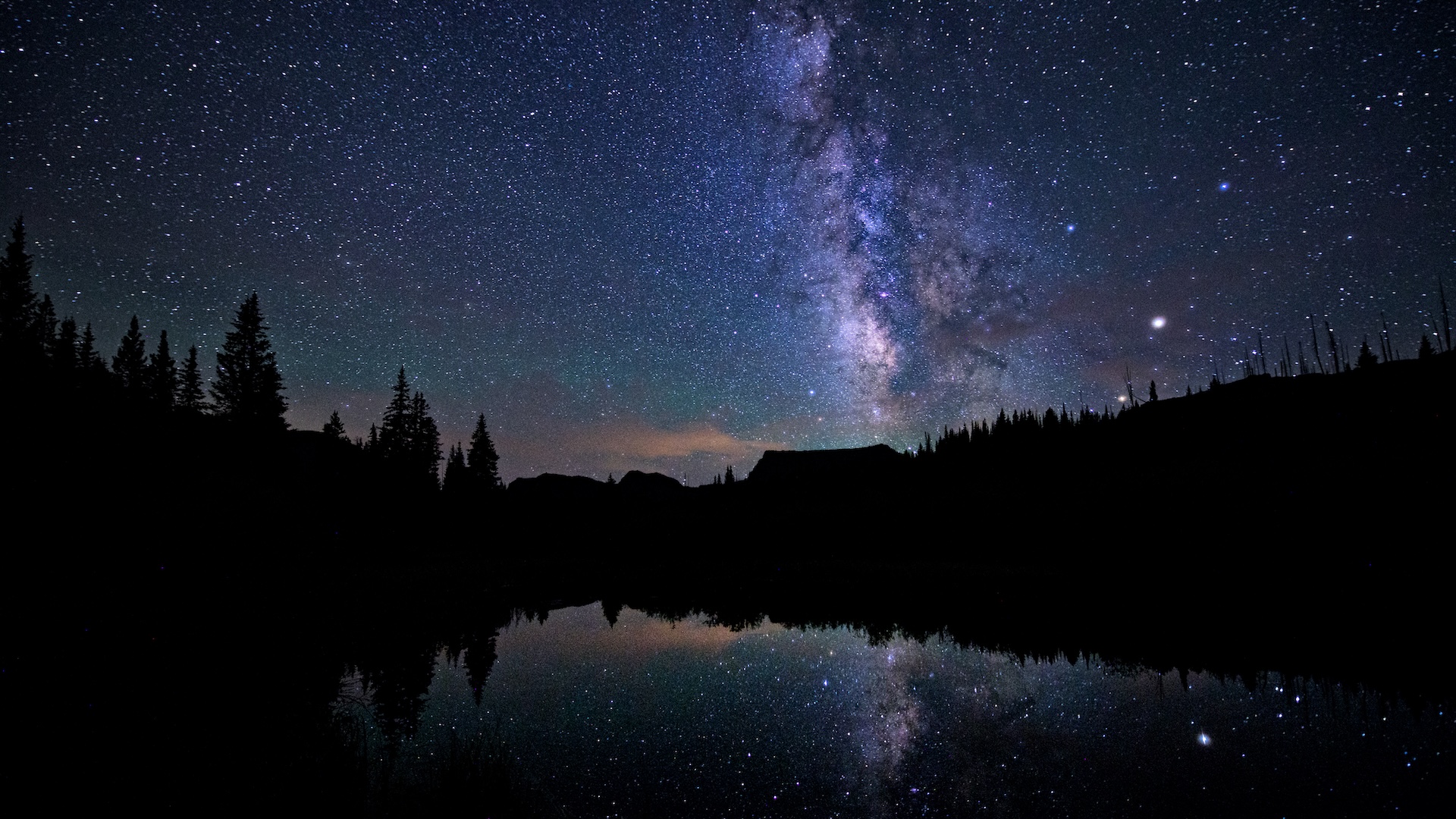 a photograph of the Milky Way over a lake at night