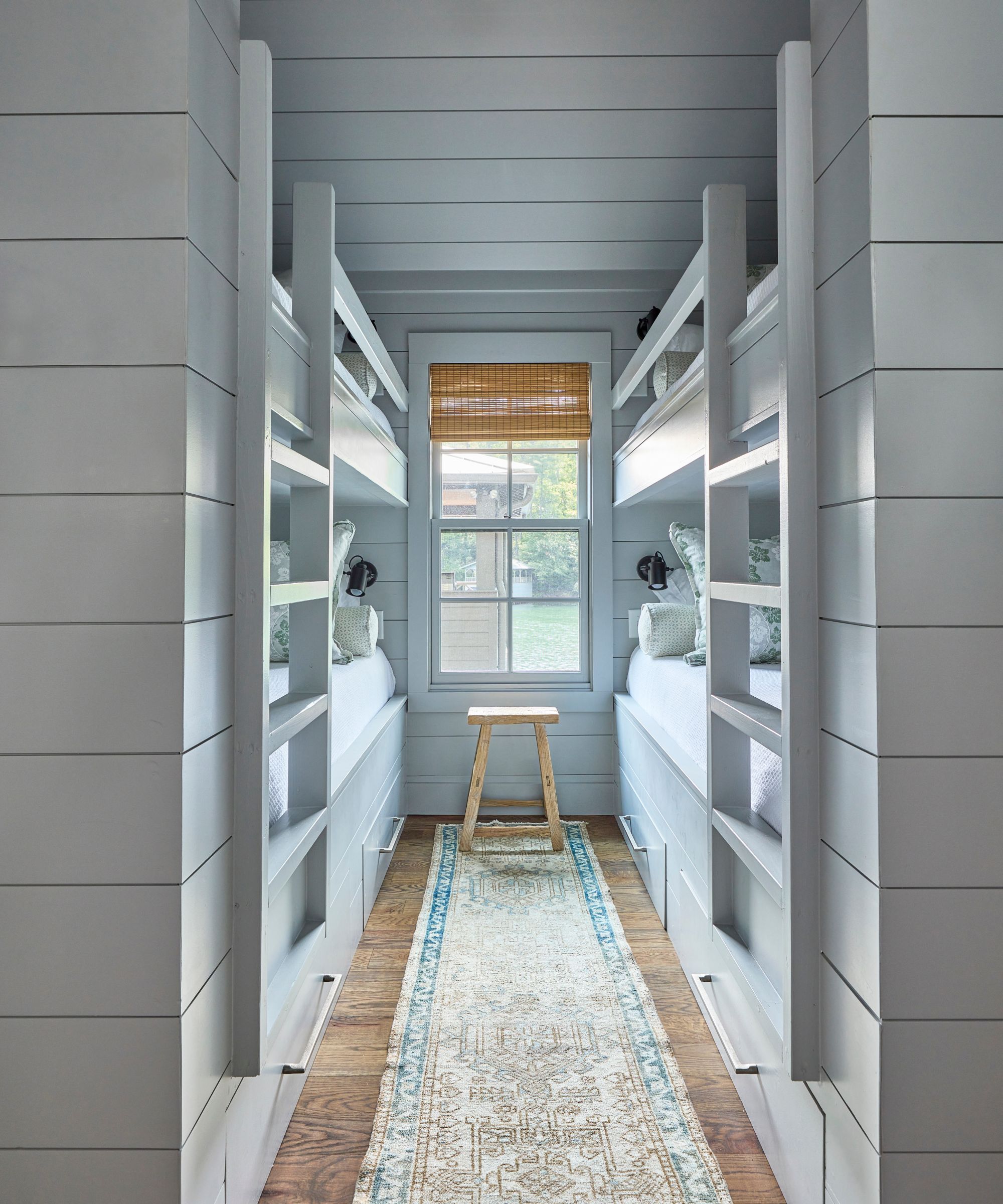 A color-drenched pale blue kids' bedroom with two built-in bunk beds.