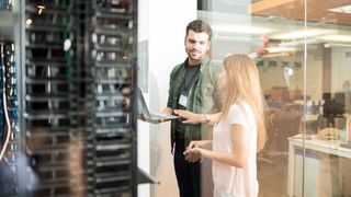 man and woman stood in office by data center