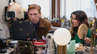 L-R: Ned (Domhnall Gleeson) and Esmeralda (Sabrina Impacciatore) sitting at a computer desk in a scene from "The Paper"