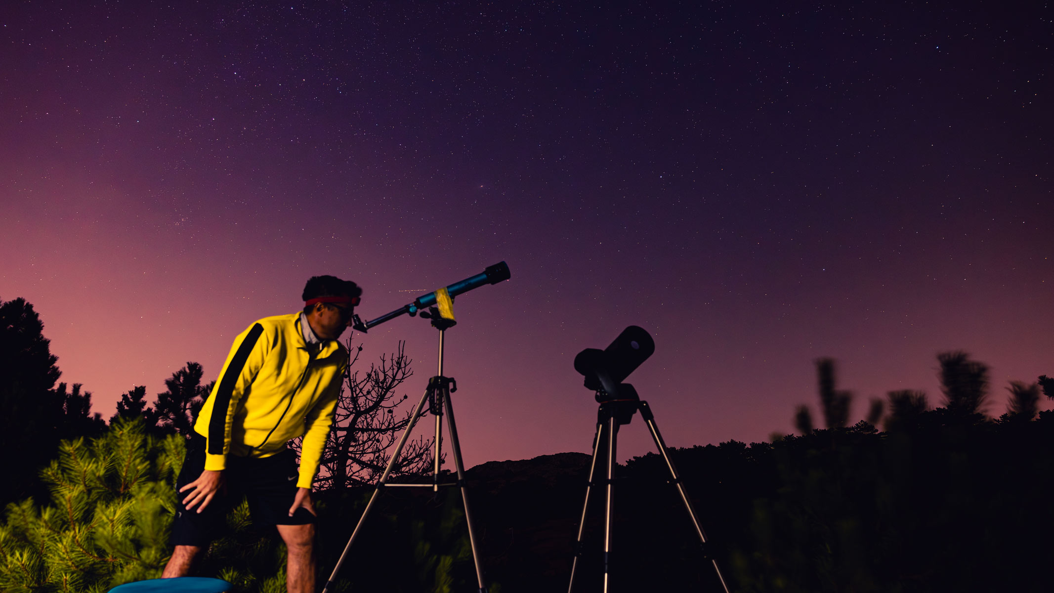 A person using a telescope to view the night sky.