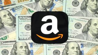 Amazon app logo pictured in front of $100 dollar bills