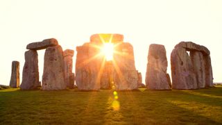 Sun shining through the stone arrangement at Stonehenge, UK.