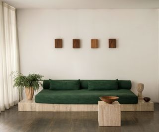 living room with white walls and green sofa