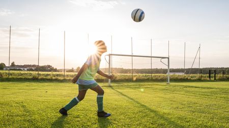 Young football player heading the ball 