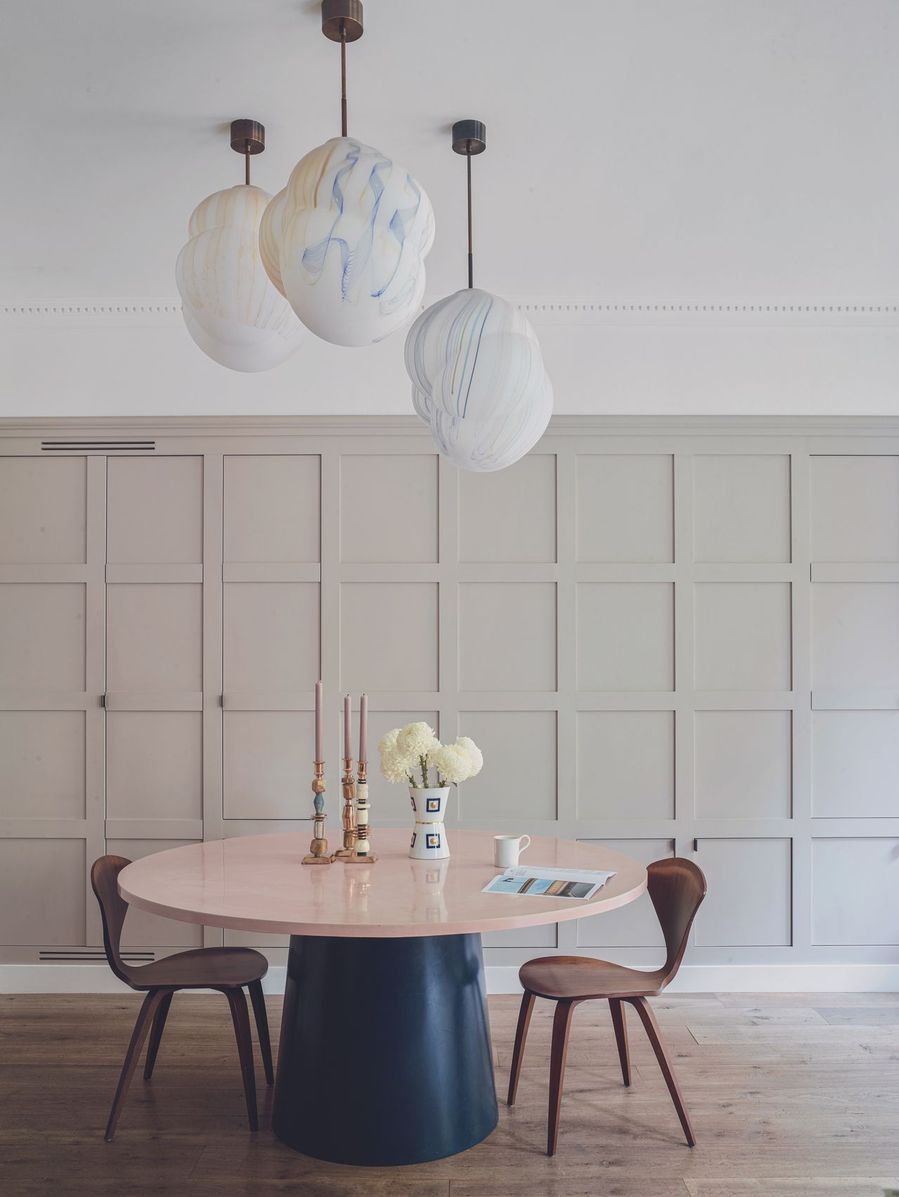 The panelled dining area with artistic hanging lights and a large round table
