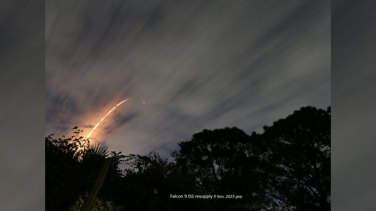 a rocket launches below a full moon with a halo around it