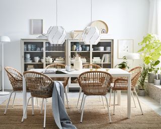 Dining area by IKEA with rattan chairs, white floor lamp and white lampshades
