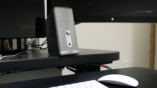 Bose computer speakers pictured on a desk next to a computer