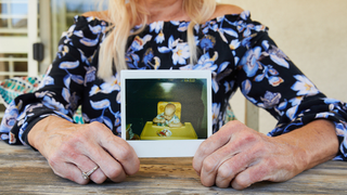Mother Diane holds a polaroid of her son James as baby