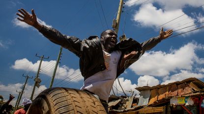 Man stretches out his arms during protest in Nairobi