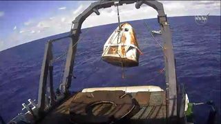 A recovery ship hauls SpaceX's first Crew Dragon capsule out of the Atlantic Ocean after the spacecraft's splashdown on March 8, 2019.