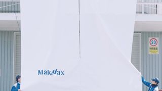 A still from a YouTube video showing a giant sheet of fabric being zipped up by a self-propelled zipper