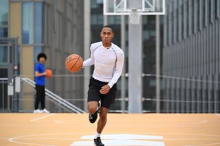 Person in playing basketball on a rooftop basketball court