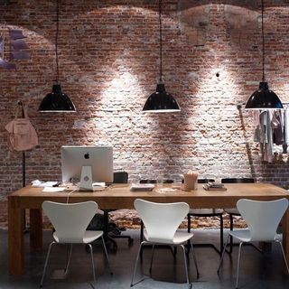 work space with work desk and chairs red brick wall