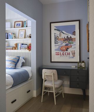 A kids bedroom with blue walls and a cubby hole bed with under-bed drawers