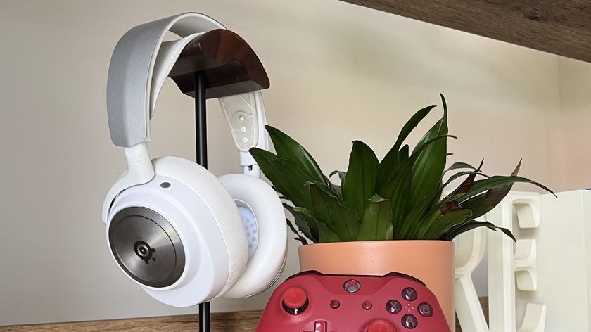White SteelSeries Arctis Nova Pro Wireless with Xbox Series X controller on a shelf with a pot plant