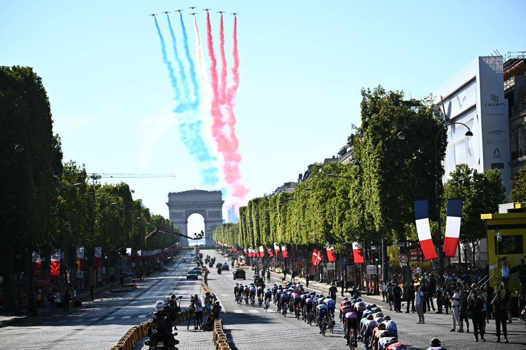 TOPSHOT The pack of riders compete as the French elite acrobatic flying team Patrouille de France PAF flies over the ChampsElysees during the 21st and final stage of the 109th edition of the Tour de France cycling race 1156 km between La Defense Arena in Nanterre outside Paris and the ChampsElysees in Paris France on July 24 2022 Photo by AnneChristine POUJOULAT AFP Photo by ANNECHRISTINE POUJOULATAFP via Getty Images