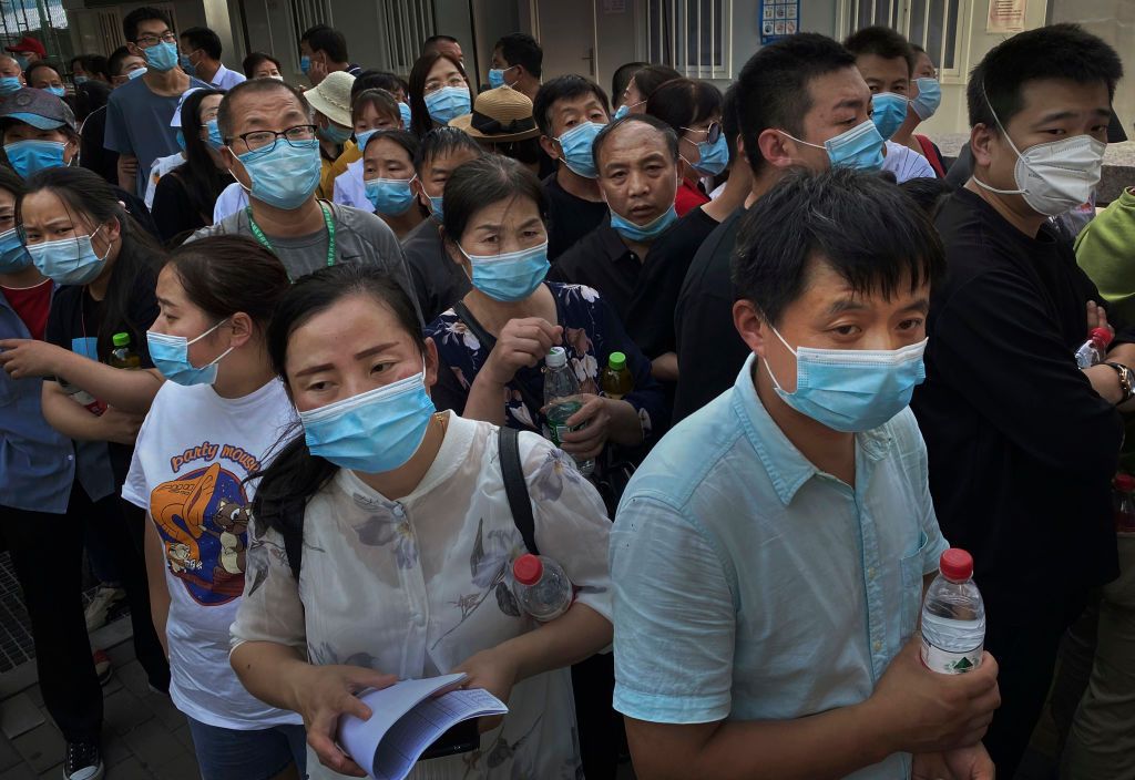 People who have had contact with the Xinfadi Wholesale Market or someone who has, line up for a nucleic acid test for COVID-19 at a testing center on June 16, 2020 in Beijing, China.