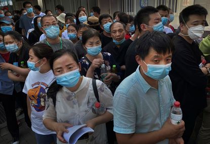 People who have had contact with the Xinfadi Wholesale Market or someone who has, line up for a nucleic acid test for COVID-19 at a testing center on June 16, 2020 in Beijing, China.