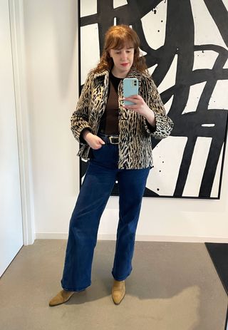 a woman wears a leopard jacket with wide-leg jeans and brown boots