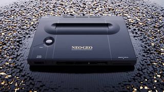 Neo Geo AES+ console in black sitting on fragmented surface made of black cubes.