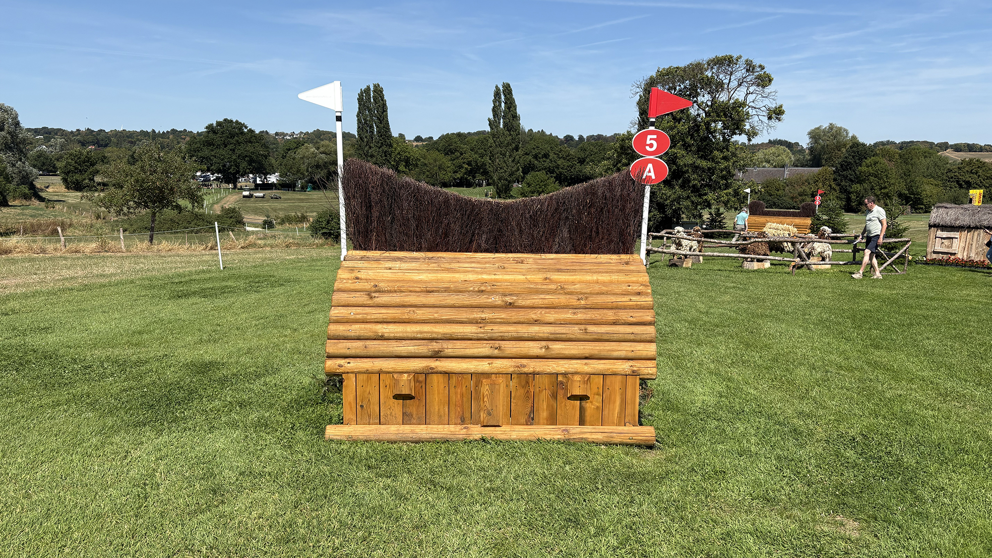 A wooden fence with shaped brush on the top of it on the eventing World Championships cross-country course in Aachen