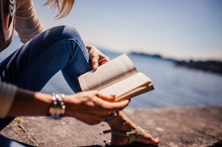 Woman reading novel on the beach
