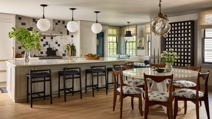 off-white kitchen with wood floor and round dining table and chairs