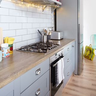 kitchen room with white tiles on wall and chimney