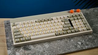 The Lofree Block keyboard on a stone surface with a blue wall in the background.