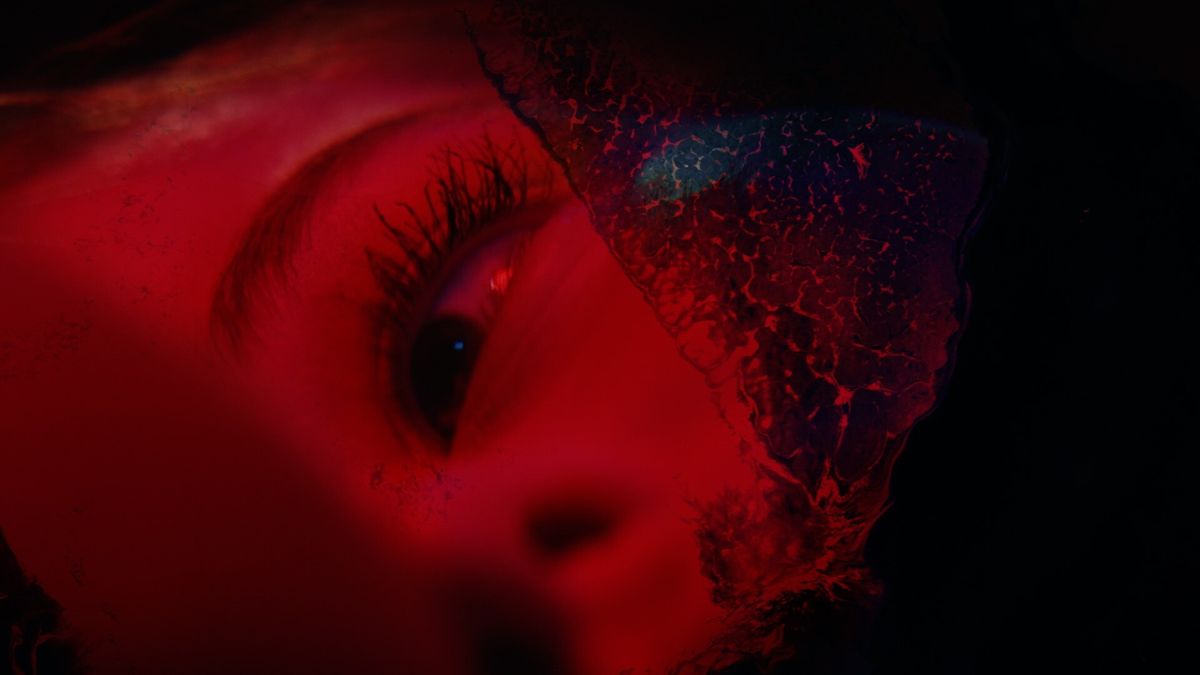 A broken image of a woman&#039;s face drenched in red light in a teaser image from Half Mermaid&#039;s Project C