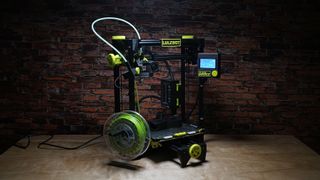 Lulzbot TAZ Sidekick 747 against a brick wall in a dark room