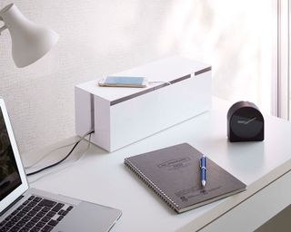 White cable management box on white desk