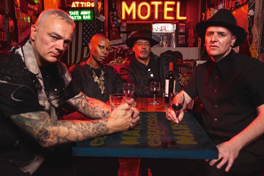Skunk Anansie sitting around a pub table