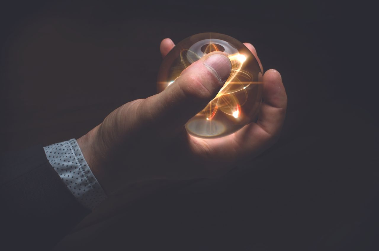 Holding atom in fortune teller magic crystal ball