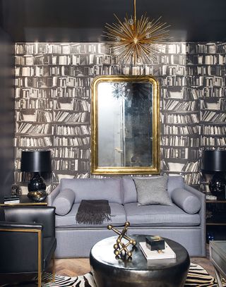 Grey living room with wallpaper designed to mimic a bookshelf