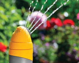 close up of bright yellow garden sprinkler head, model Round Sprinkler Plus from Hozelock