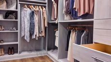 A well stocked walk in closet with all clothing and shoes organized within