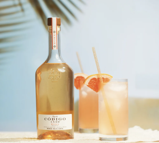 an image of the C&amp;oacute;digo 1530 rosa tequila next to two paloma cocktails