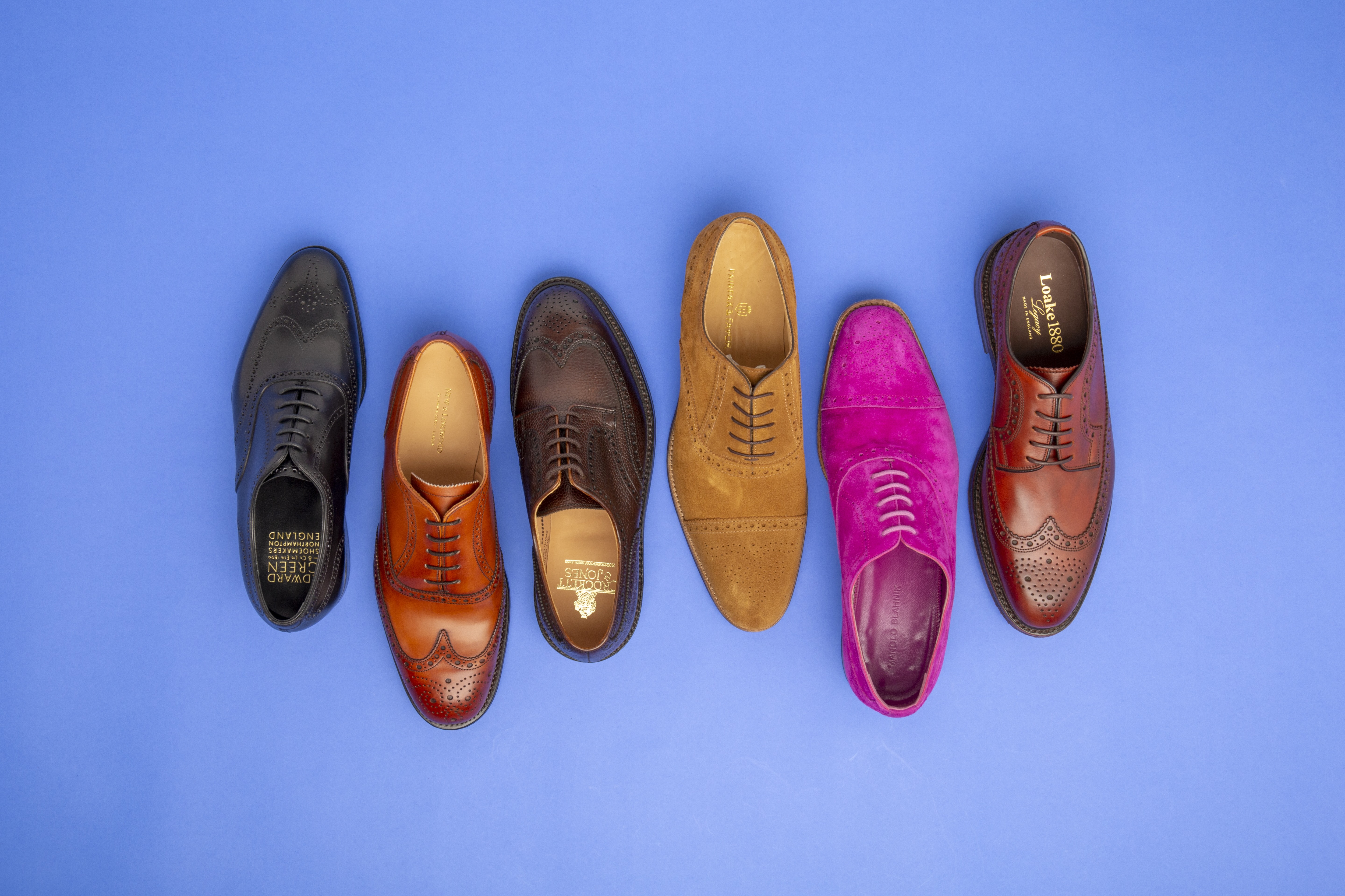 Flat lay photograph of brogue shoes on a bright blue background