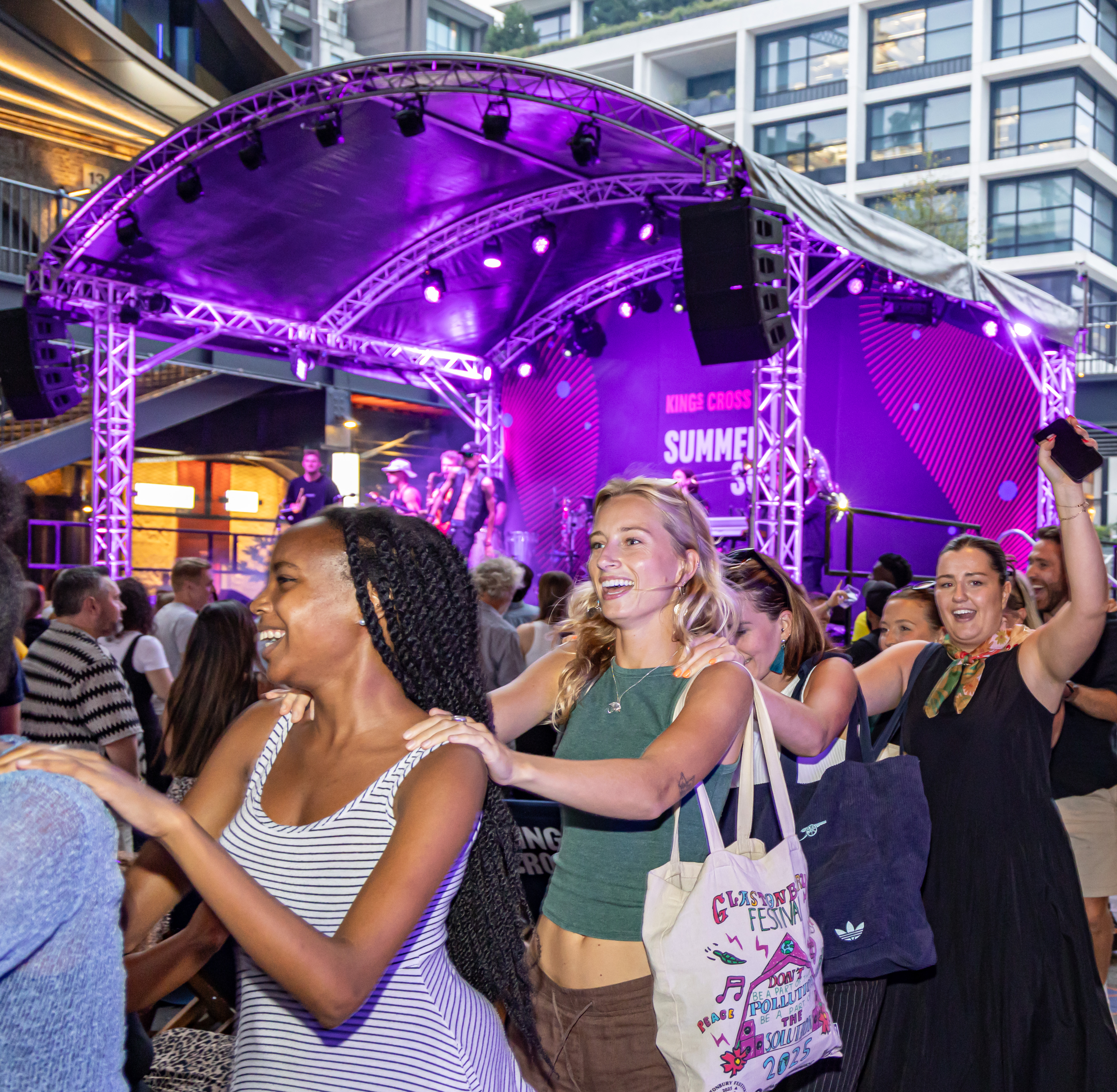 an image of people dancing in a conga line in King's Cross during the Summer Sounds festival