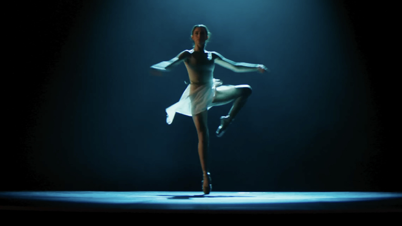 Ana de Armas in wearing white leotard, mid spin, starring in Ballerina. 