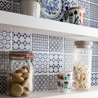 blue tile designed wall white shelf and food jars