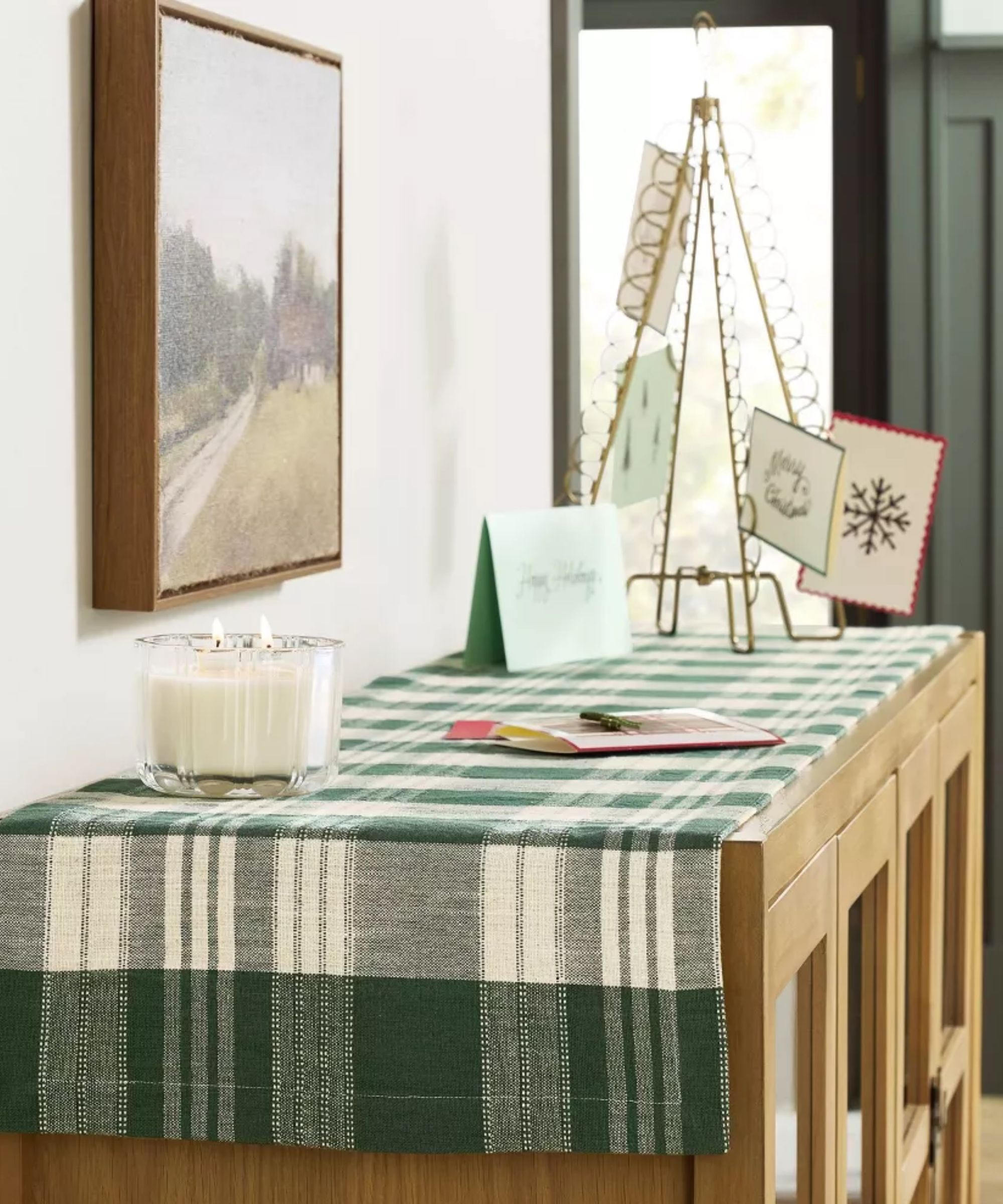Sideboard with green and white plaid runner and white candle