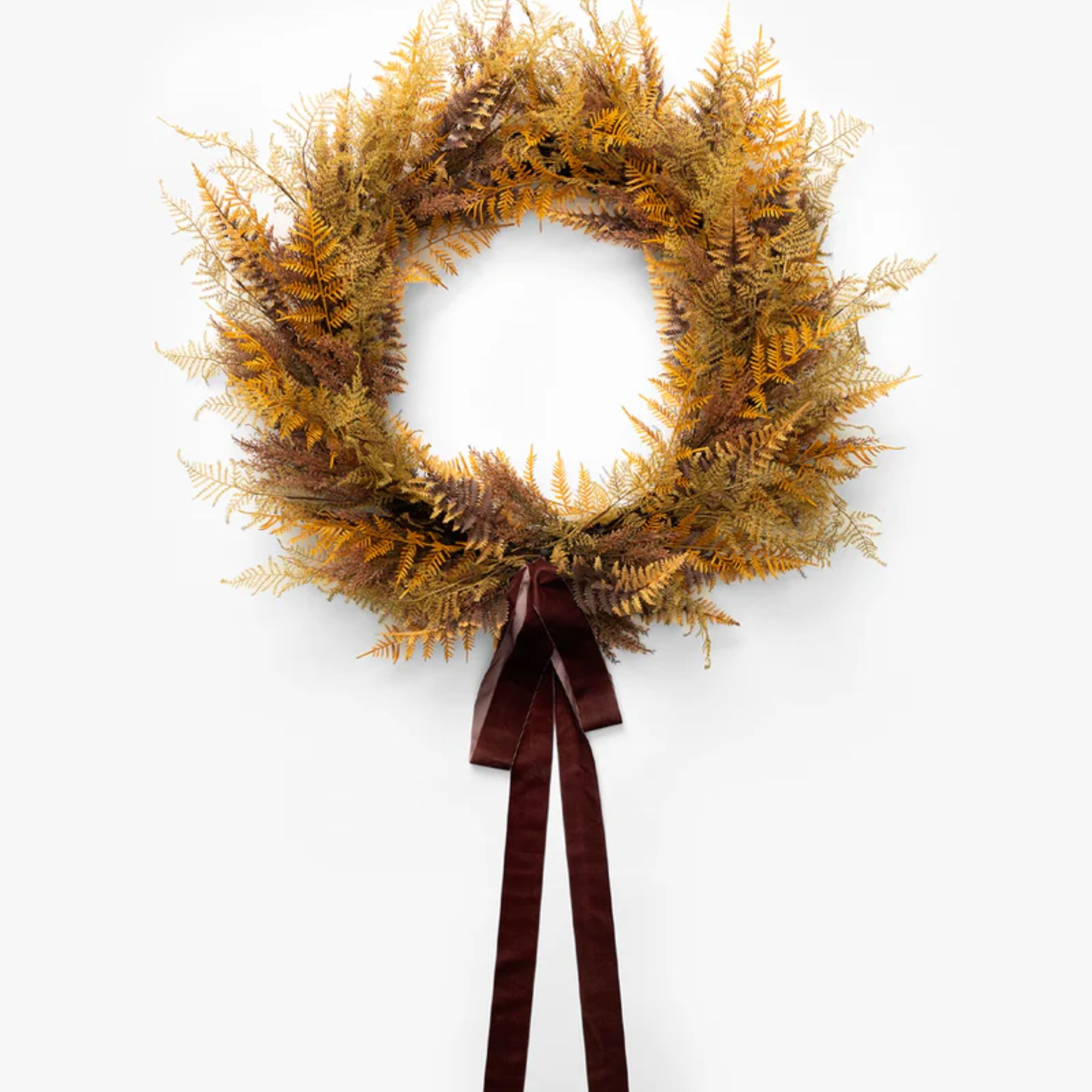 Yellow faux fern wreath with red velvet ribbon detail