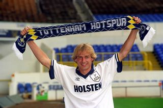 Jurgen Klinsmann poses with a scarf after signing for Tottenham in 1994