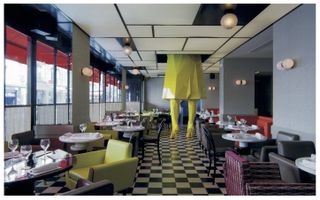 Colourful interior of Germain bistro by India Mahdavi, with giant model of woman's legs in neon