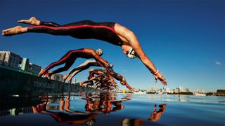 Swimmers diving into the water at Odaiba Marine Park at Tokyo 2020.