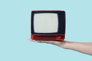 A small television perched on the palm of a hand